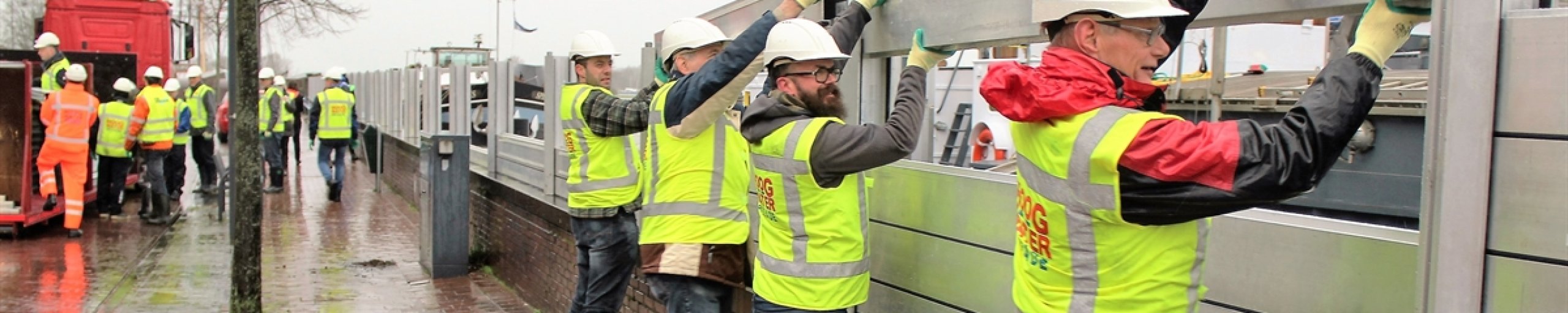 Hoogwaterbrigade zet waterkering in elkaar